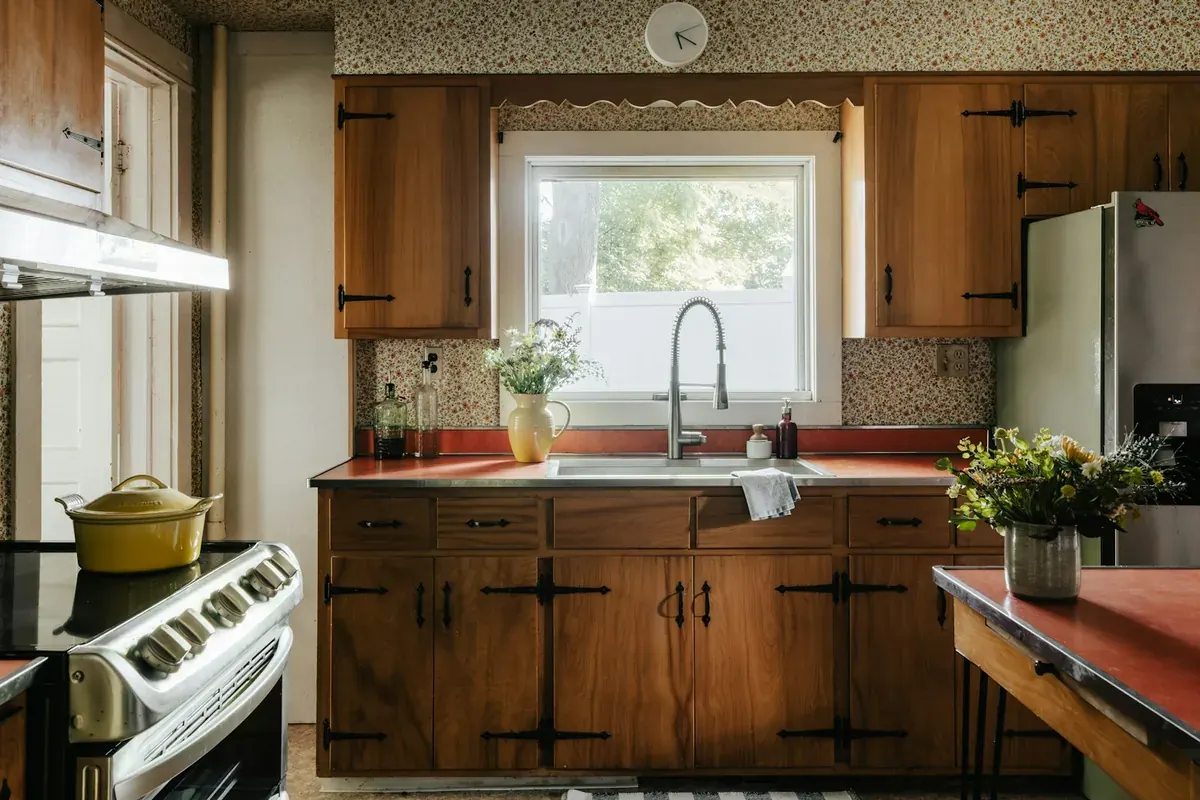 Dated wood kitchen cabinets with strap hinges and tile counters in a California house